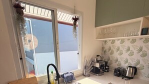 A modern kitchen with a sink, countertop, and various appliances. - Quiet family-friendly villa in the city center (Chang Wat Surat Thani)