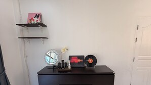 A black desk with a mirror, a vase with a flower, a framed picture, and a vinyl record. - Quiet family-friendly villa in the city center (Chang Wat Surat Thani)