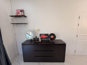 A black desk with a mirror, a vase with a flower, a framed picture, and a vinyl record. - Quiet family-friendly villa in the city center (Chang Wat Surat Thani)