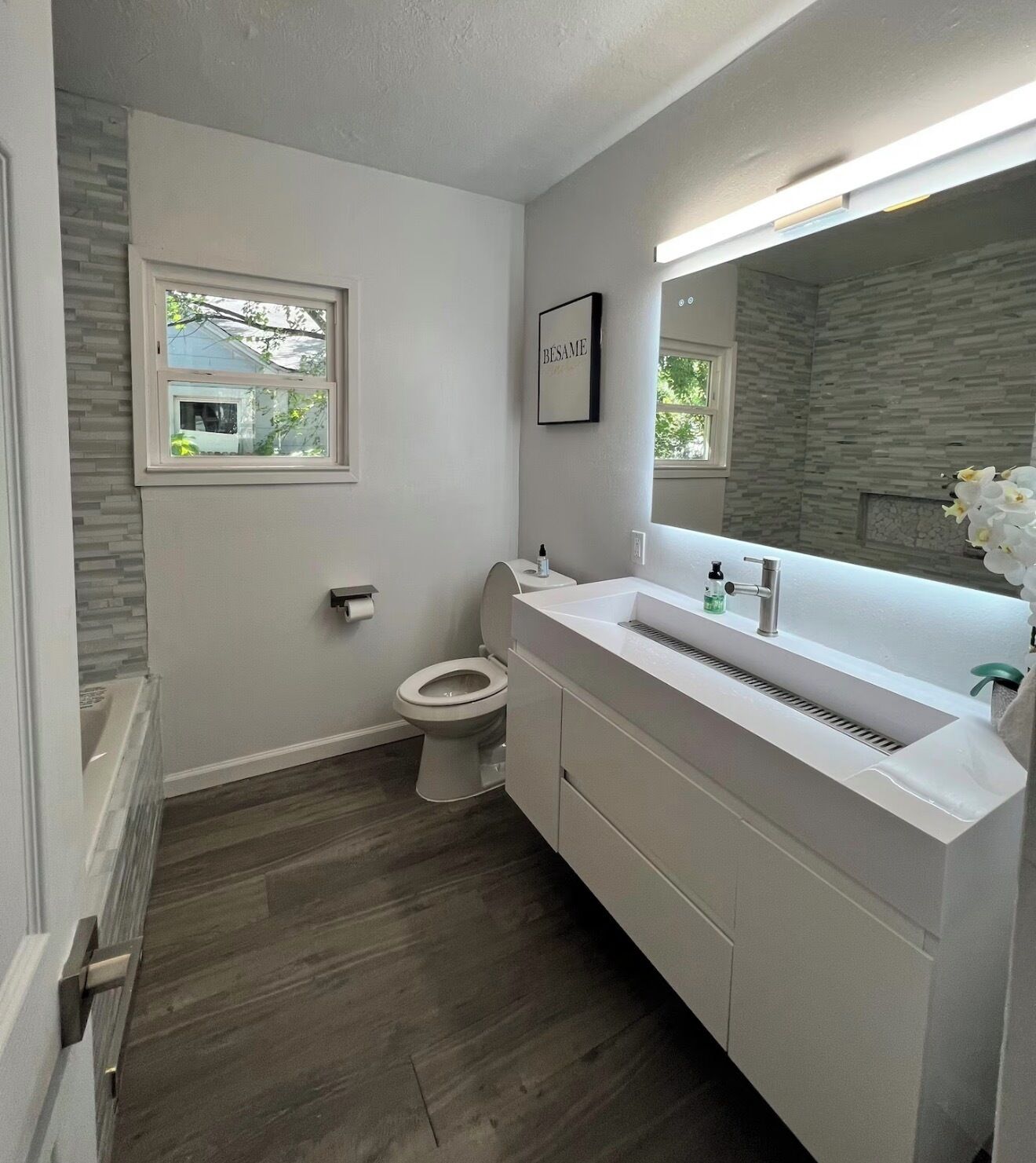 Ein modernes Badezimmer mit Toilette, Waschtisch und Fenster.