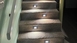 Eine Treppe mit Teppichstufen und eingebauten Leuchten.