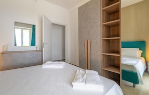 A hotel room with a bed, a wardrobe, a mirror, and a door. - Nice apartment in Scicli with house sea view (Scicli)