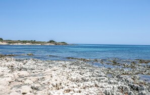 A rocky beach with clear blue water and a distant shoreline. - Pet friendly home in Ispica (Ispica)