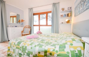 A bedroom with a bed, a dresser, a chair, a window, and a bookshelf.