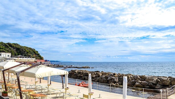 Terraza frente al mar con asientos al aire libre y vistas al océano.