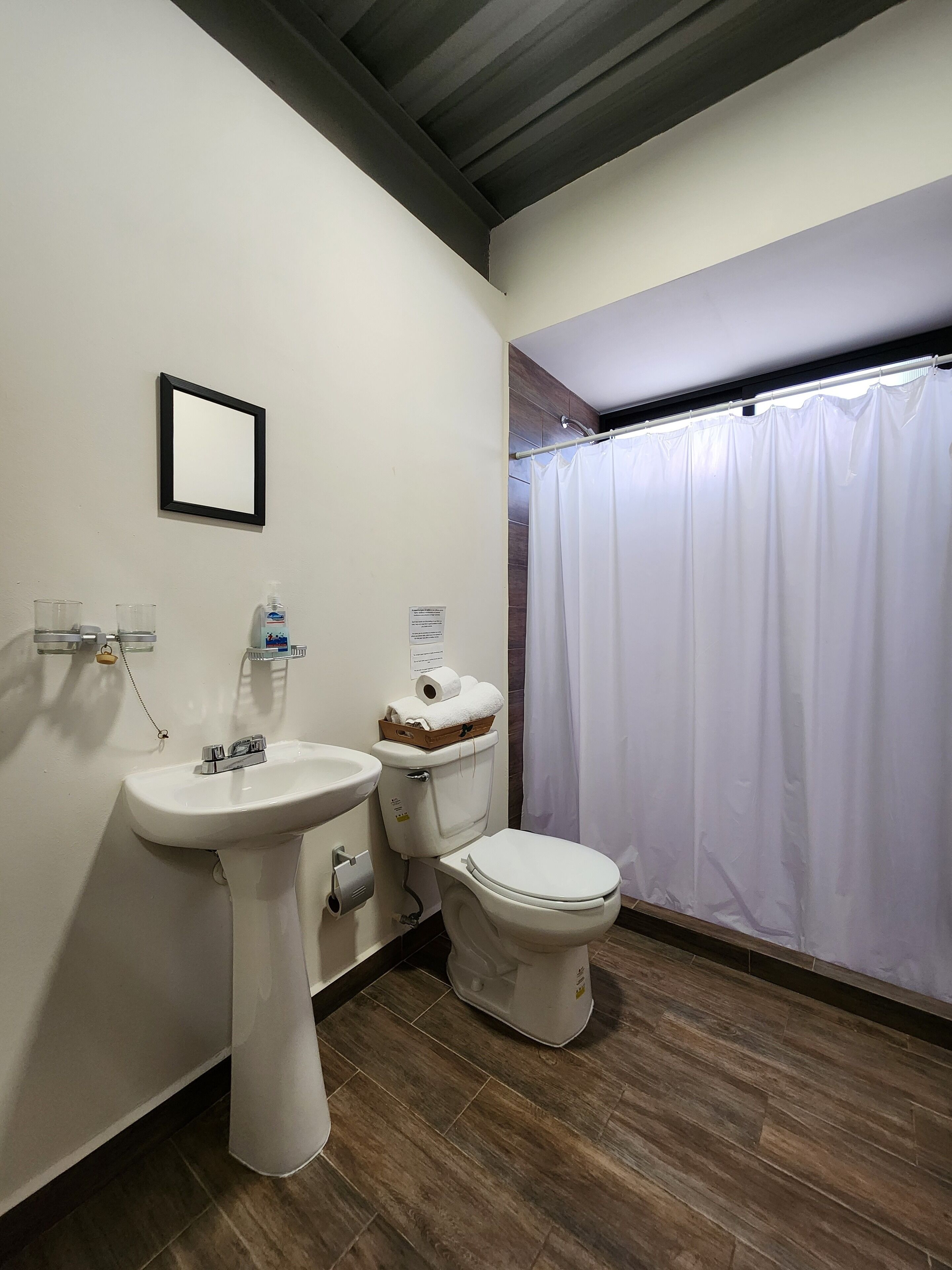 A bathroom with a sink, toilet, and shower curtain.