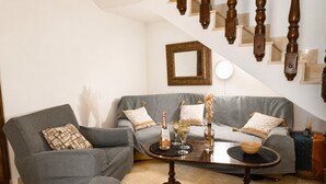 Un salon avec un canapé gris, une table basse et un escalier doté de balustrades en bois.