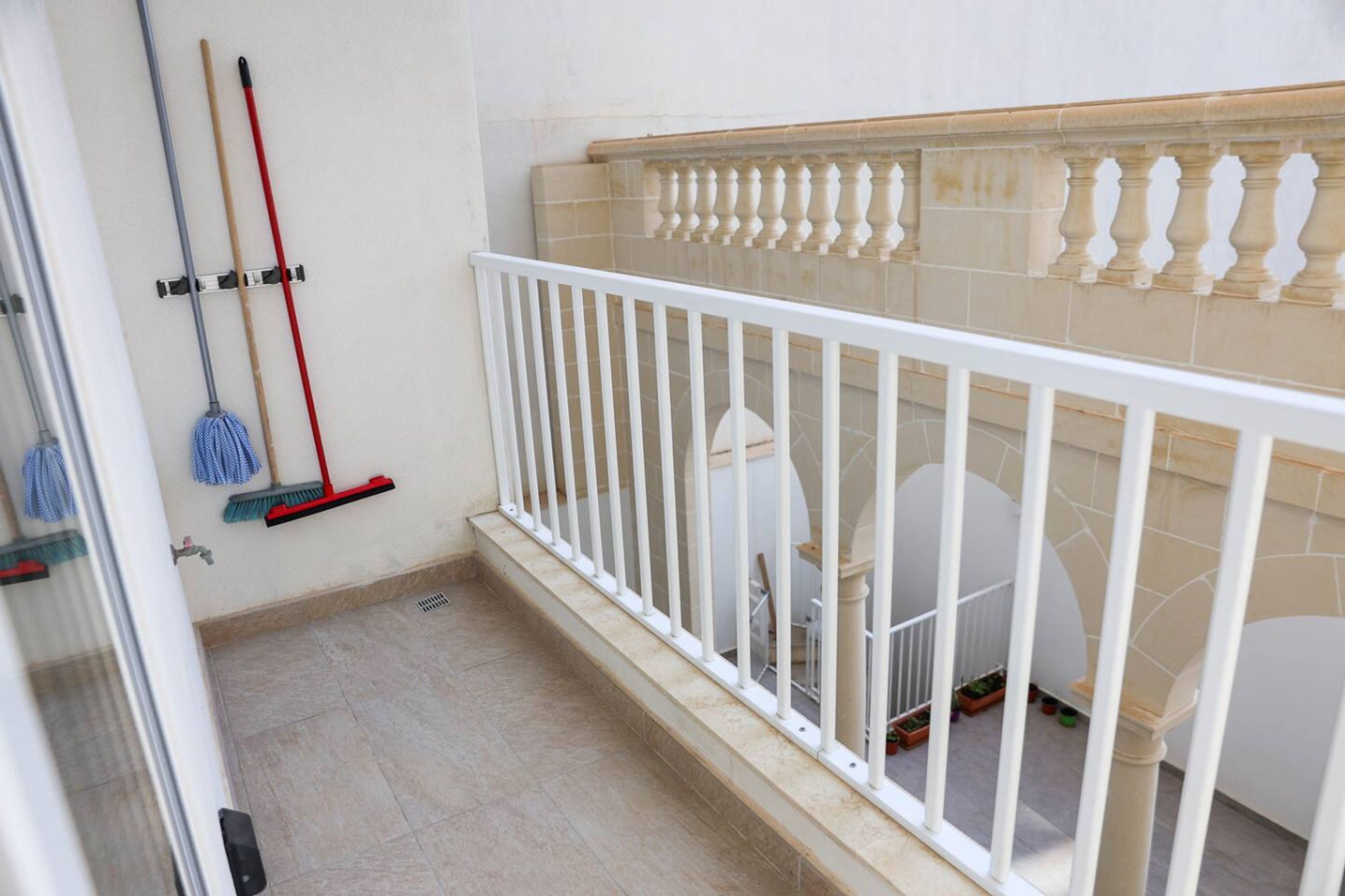 A clean, well-maintained bathroom with a white bathtub, a shower area, and a white railing.