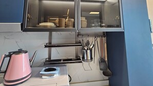 A kitchen with a microwave, kettle, and utensils on the counter. - 용두산공원 뷰 및 바다뷰, 지하철역 2분거리!! 숙소 바로 앞 먹자골목, 국제시장 6분거리!! (Busan)