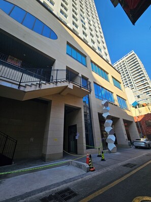 A modern building with a prominent staircase, large windows, and a unique spiral design element. - 용두산공원 뷰 및 바다뷰, 지하철역 2분거리!! 숙소 바로 앞 먹자골목, 국제시장 6분거리!! (Busan)