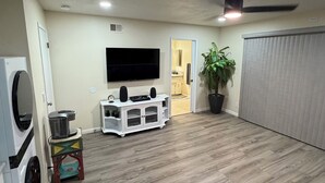 A living room with a flat-screen TV, a ceiling fan, and a potted plant. - Wine Country Retreat Private Entry (Santa Maria)