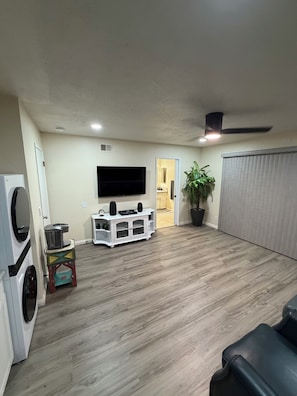 A living room with a flat-screen TV, a ceiling fan, and a potted plant. - Wine Country Retreat Private Entry (Santa Maria)