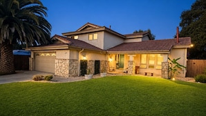 A two-story house with a stone facade, a garage, and a well-maintained lawn. - Wine Country Retreat Private Entry (Santa Maria)