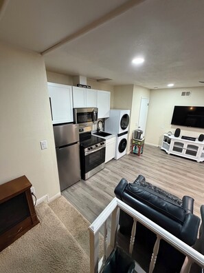 A compact living space with a kitchenette, a flat-screen TV, and a seating area.