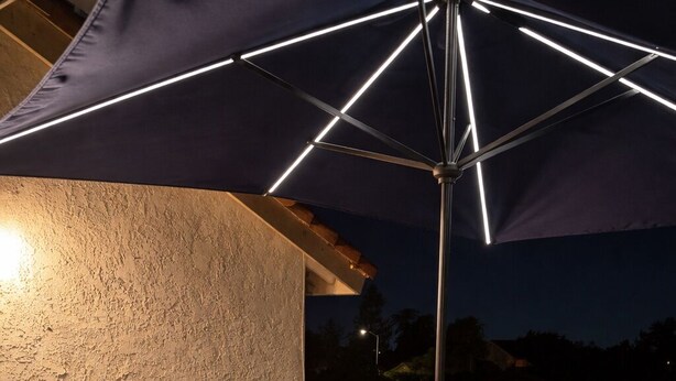 An outdoor deck with a fire pit, wicker furniture, and a large umbrella.