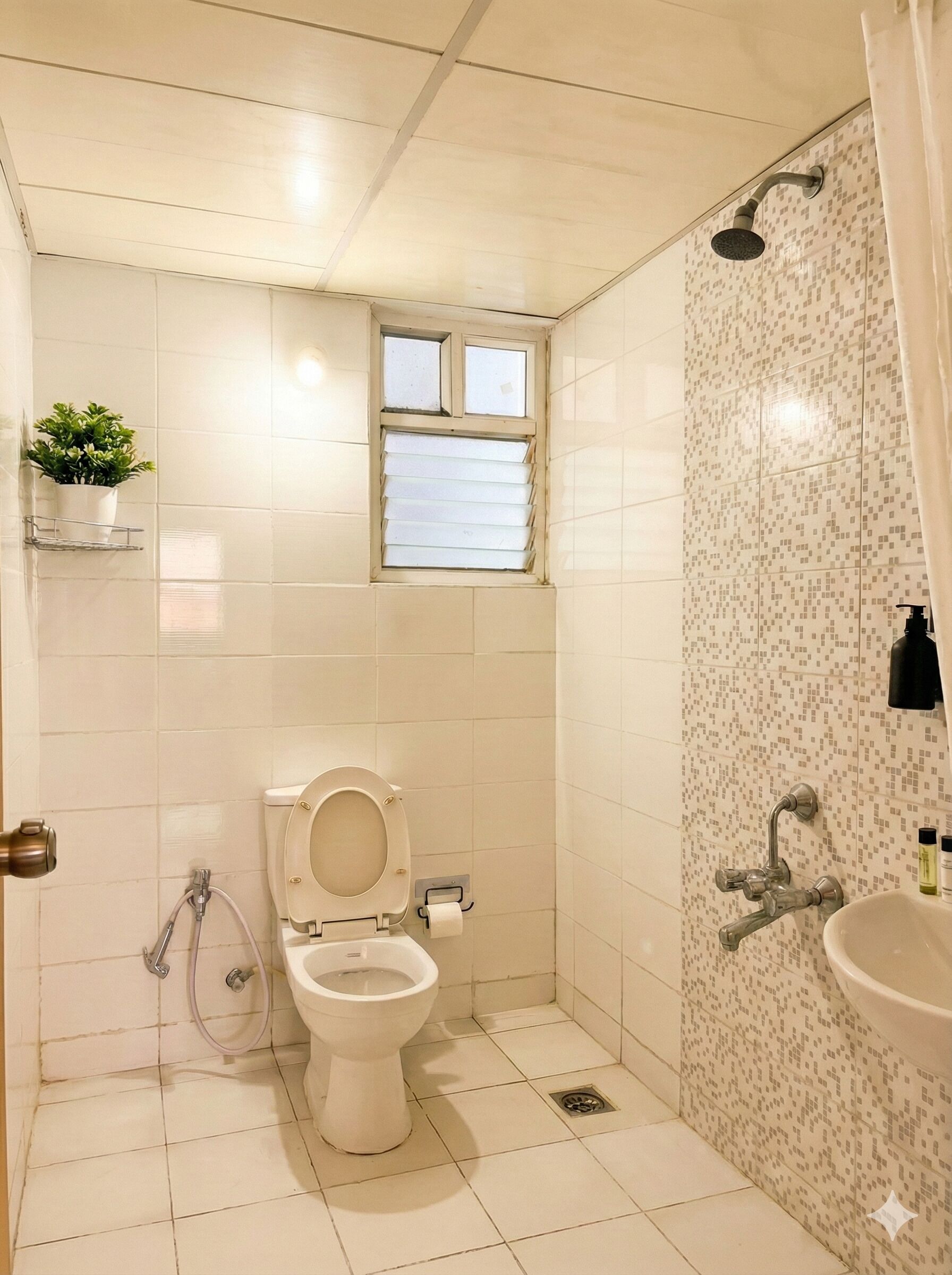 Une petite salle de bain comprenant des toilettes, une douche, une fenêtre et un lavabo.