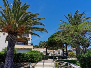 A resort with palm trees, a pool, and a building with balconies. - JARDINS D'YS Studio for 2 people with air conditioning (LES ISSAMBRES)