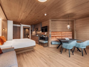 Ein modernes Schlafzimmer mit einem großen Bett, einem Schreibtisch und einem Essbereich.
