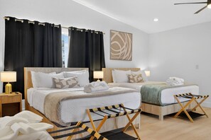 A hotel room with two beds, a view of the outdoors, a ceiling fan, and a painting on the wall. - Vegas Stays with Games, Volleyball, and More! (North Las Vegas)