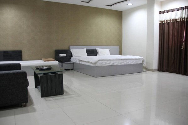 Una habitación de hotel moderna con una cama grande, un sofá, una pequeña mesa y una mesita de noche.