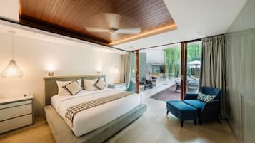 A modern hotel room with a large bed, a ceiling fan, a desk, and a view of the outdoor patio.