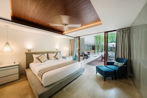 A modern hotel room with a large bed, a ceiling fan, a desk, and a view of the outdoor patio.