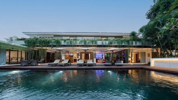 Un hôtel moderne doté d’une piscine, d’un espace extérieur aménagé et d’une végétation luxuriante.