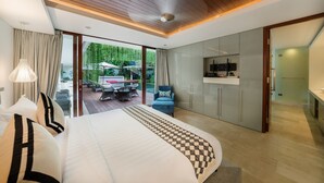 Une chambre d’hôtel moderne dotée d’un grand lit, d’un coin repas avec des sièges en plein air et d’une kitchenette.