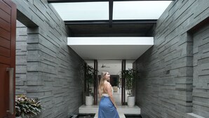 Un intérieur moderne avec un plafond en verre, une allée centrale et un bassin à carpes koï.