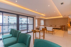 A modern living room with a sofa, a dining table, and a kitchen area. - Studio de Alto Padr o com Piscina na Vila Mariana (São Paulo)