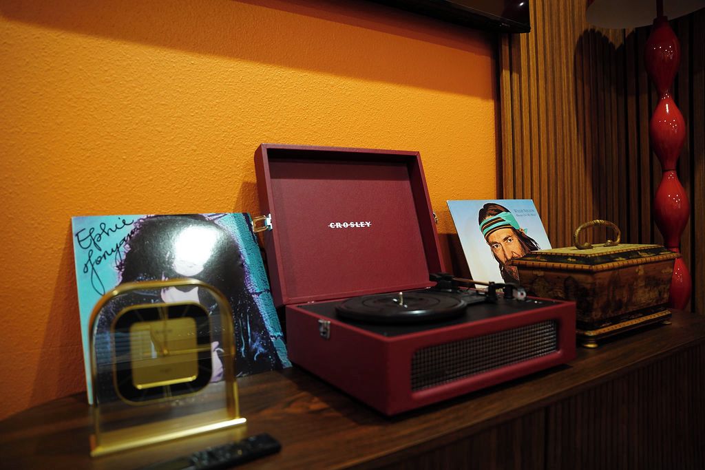A vintage Crosley radio on a wooden surface with a red box and a framed picture.