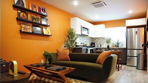 A modern living room with a green sofa, a coffee table, and a bookshelf with vinyl records. - The Tangerine Retreat - Retro Dallas Downtown Vibe (Dallas)
