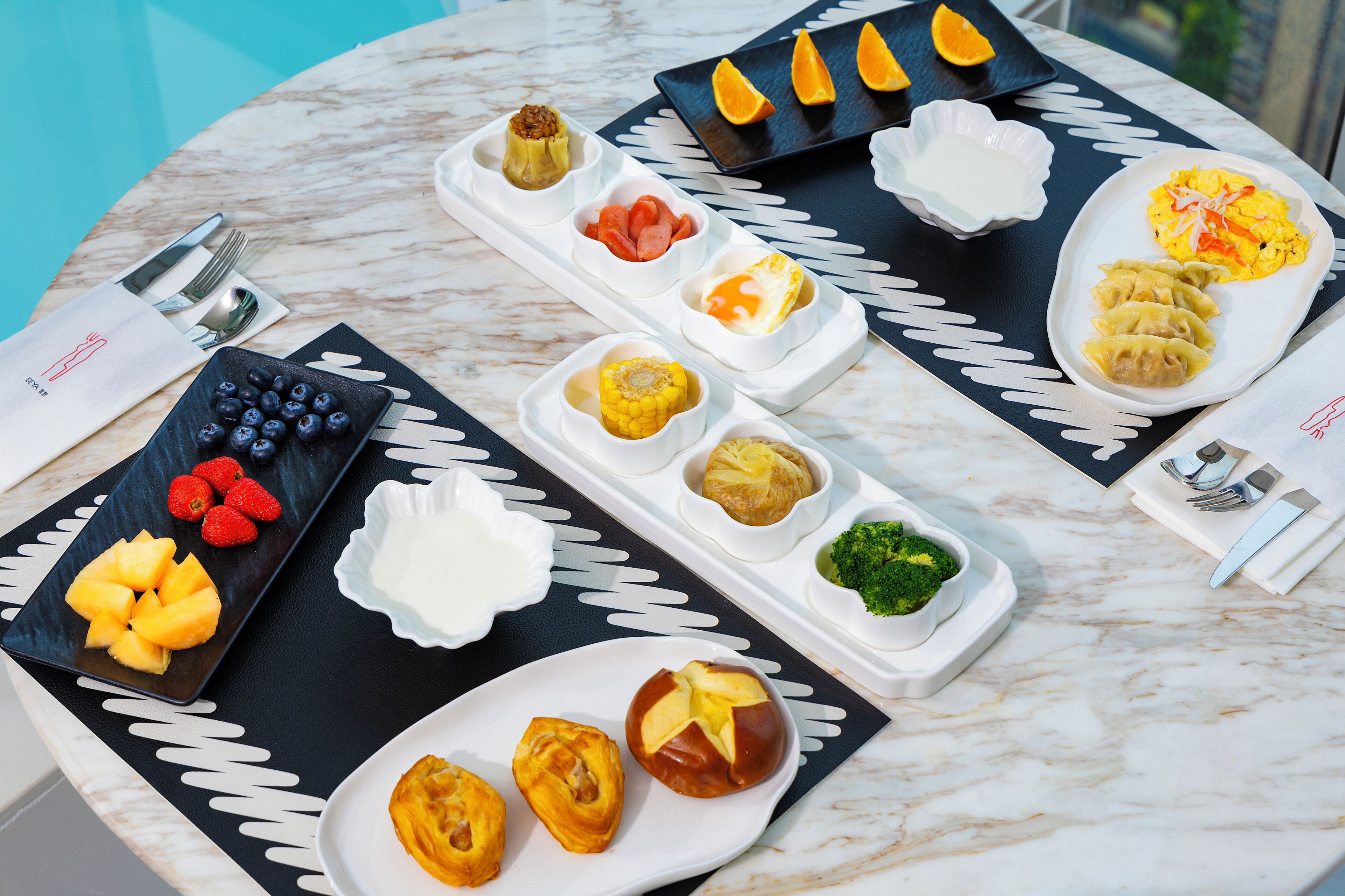Una mesa con diversos alimentos y utensilios, dispuesta sobre una superficie de mármol.
