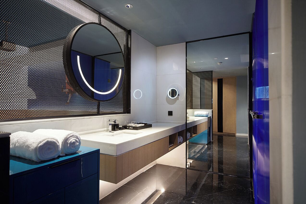 A modern bathroom with a large mirror, a sink, and a glass-enclosed shower area.
