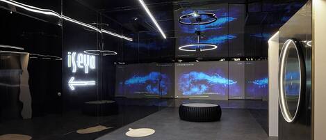 Un intérieur moderne avec un mur de verre, un néon et un espace salon circulaire.