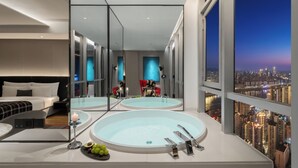 A modern hotel room with a large bed, a bathroom with a bathtub, and a city view. - SEYA Panoramic Hotel - Chongqing Cloud Eye - Managed by SEYA GROUP (Chongqing)