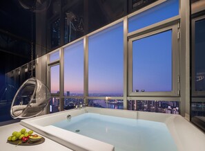 A modern bathroom with a large bathtub, a hanging chair, and a city view through large windows. - SEYA Panoramic Hotel - Chongqing Cloud Eye - Managed by SEYA GROUP (Chongqing)