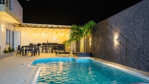Piscina interior con zona de bar y asientos.