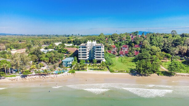 Un hôtel situé en bord de mer, composé d’un bâtiment principal, de plusieurs chambres et d’une piscine.