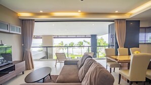 Un salon moderne avec un canapé, un téléviseur et un coin repas.