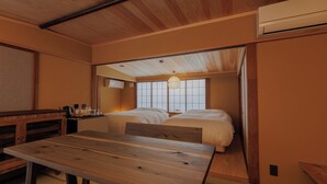 A traditional Japanese-style room with a wooden ceiling, two beds, a wooden table, and a window with a view. - NIPPONIA Niigata Furumachi Kagai (Niigata)