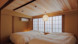 A bedroom with two beds, a ceiling fan, and a window with a view. - NIPPONIA Niigata Furumachi Kagai (Niigata)