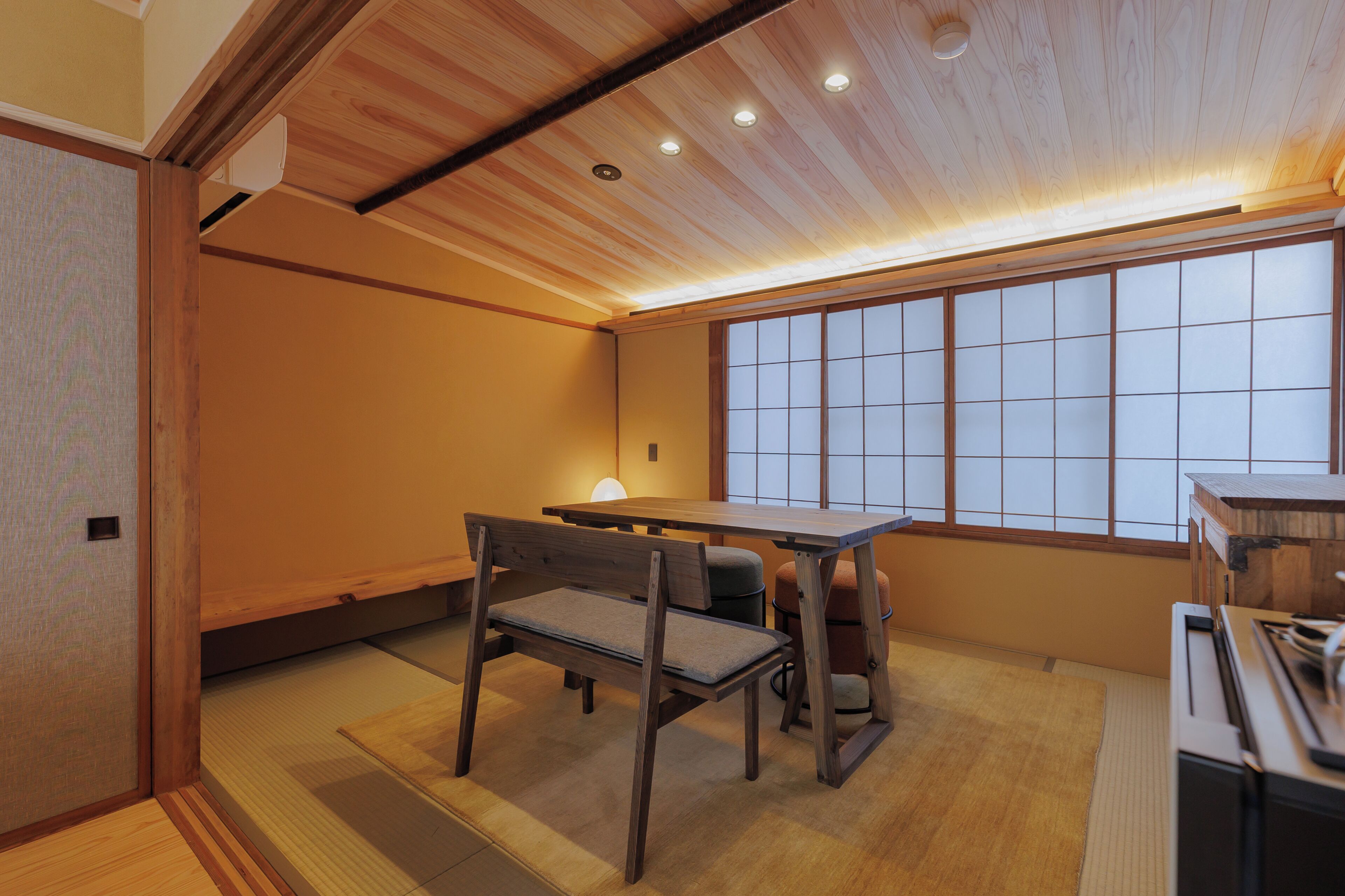 Une pièce de style japonais traditionnel, avec un sol recouvert de tatamis, une table basse et une porte coulissante.