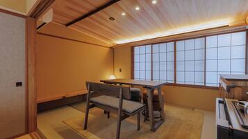 A traditional Japanese room with tatami flooring, a low table, and a sliding door.