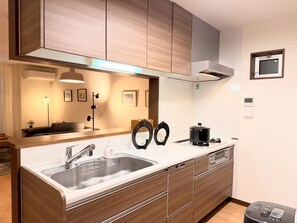 Una cocina moderna con armarios de madera, un lavamanos de acero inoxidable y un horno empotrado.
