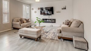 A living room with two sofas, a coffee table, and a TV mounted on the wall. - 6 Mi to Buckley Space Force Base: Getaway w/ Patio (Aurora)