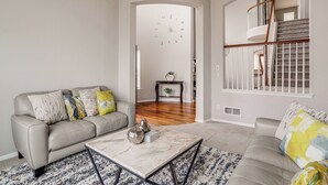 A living room with a sofa, a coffee table, and a staircase. - 6 Mi to Buckley Space Force Base: Getaway w/ Patio (Aurora)