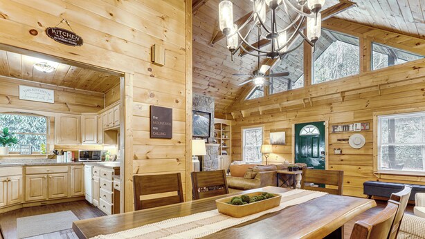 Ein Holzblockhaus mit Küche, Essbereich und Wohnzimmer.