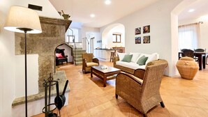 A spacious living area with a sofa, armchairs, a coffee table, and a lamp. A staircase leads to an upper level. - Podere i Prati-Tuscan vacation house in the Val D'Orcia (Chianciano Terme)