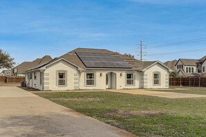 A single-story house with a sloped roof and solar panels on the roof. - Private 1-Acre Hideaway, 2 Mi to Joe Pool Lake! (Grand Prairie)